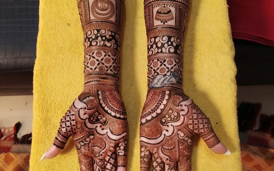 Intricate bridal henna design by Krishna Mehandi Art, a bridal mehndi artist in Kasauli. The photo shows detailed full-hand and forearm mehndi patterns featuring traditional Indian motifs like jhumkas, peacock shapes, delicate florals, paisleys, and net jaali work on a bright yellow backdrop, perfect for brides looking for wedding henna inspiration.